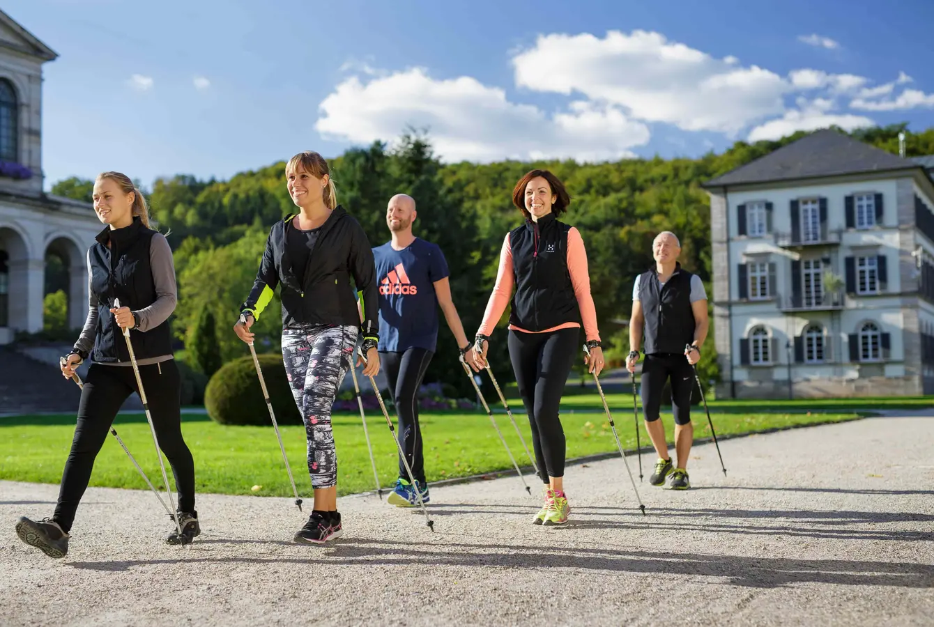 Fünf Personen beim Nordic Walking auf dem Klinikgelände der Dr. von Weckbecker Klinik